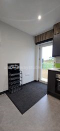 Own entrance door with large mat and shoe rack.